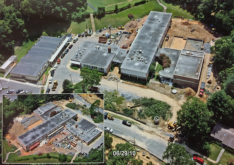 Color aerial photographs of Beech Tree Elementary School taken during renovation. Two views are shown, one taken from the northwest, and a smaller inset picture taken from the east. The grounds behind the school have been cleared and cinderblock walls are being erected. The sidewalk in front of the school has been torn up and construction equipment and supplies are visible around the building. 